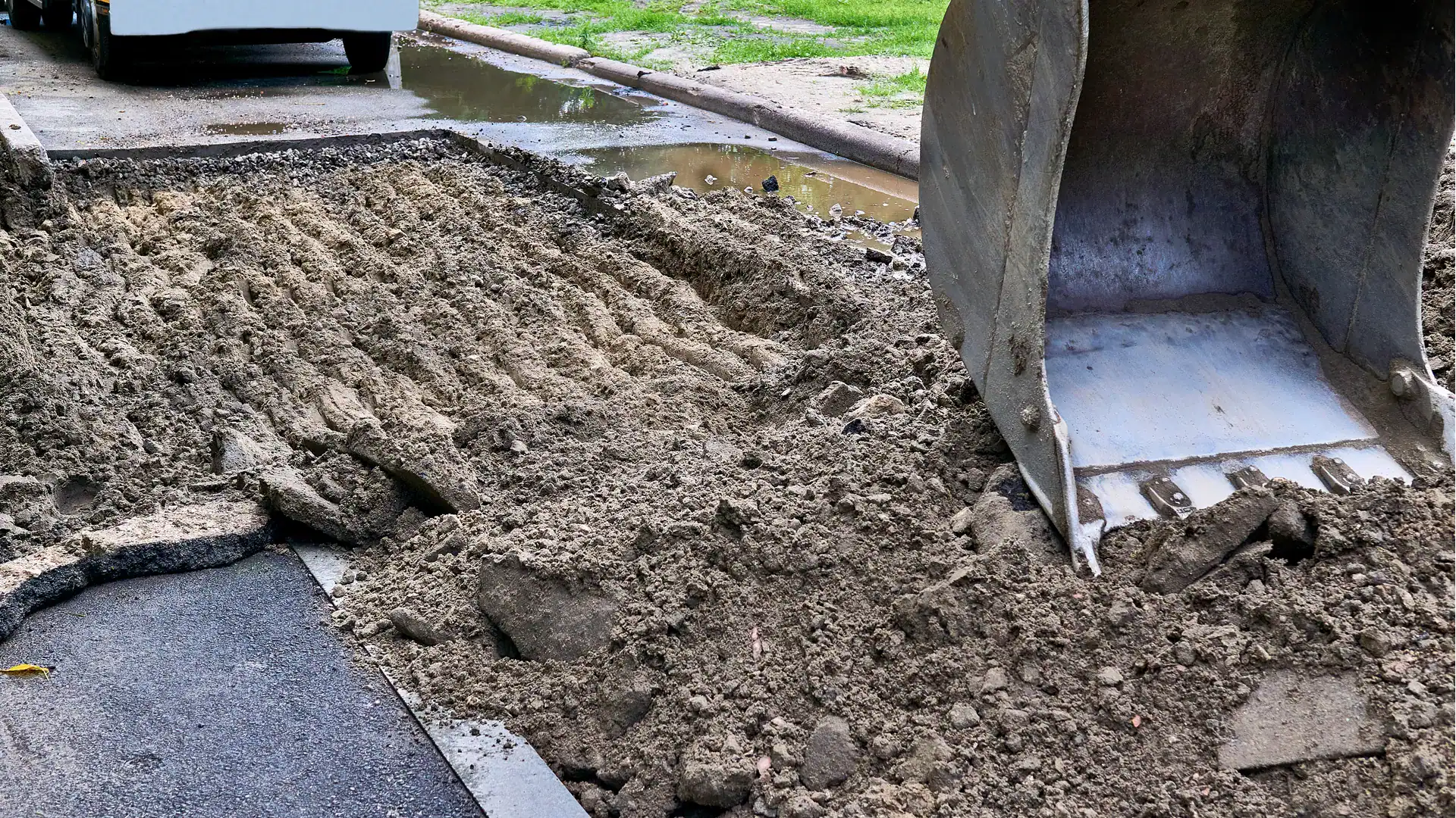 grading gravel on a driveway with a tractor bucket
