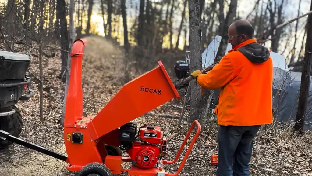 general contractor chipping ice storm debris with a chipper